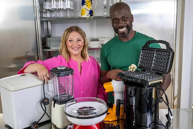 Joanna Page and Ortis Deley promoting FadTech recycling standing in a professional kitchen with kitchen appliances in front of them
