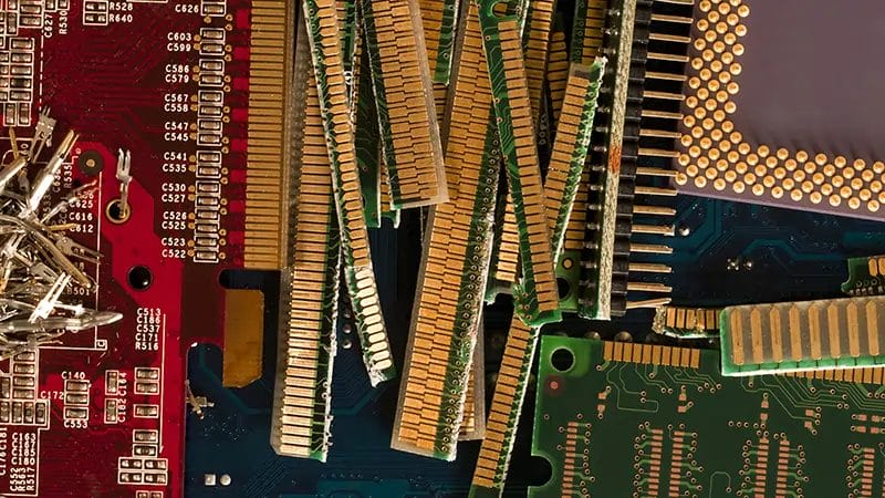 close up cropped view of a jumble of circuit boards and chips in gold, green and red