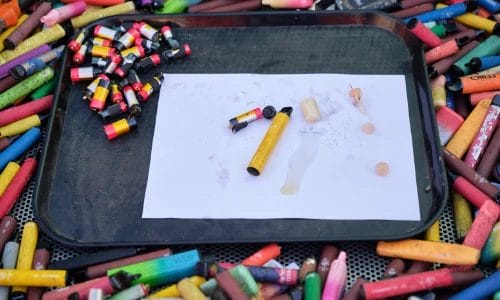 a black tray sitting on a table full of old single use vapes. Othe tray a single use vape has been pulled apart to expose the battery and its innards