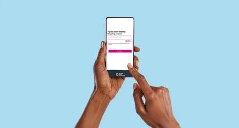 Two dark skinned hands using a mobile phone with the Recycle Your Electricals online widget, cutout on blue background