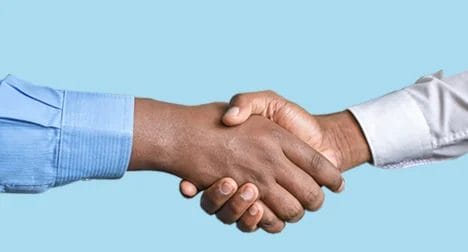 Photo shows two male dark skinned hands shaking, cutout on blue background