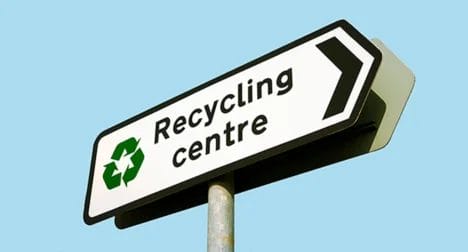 Photo showing Recyling Centre directional sign, cutout on blue background