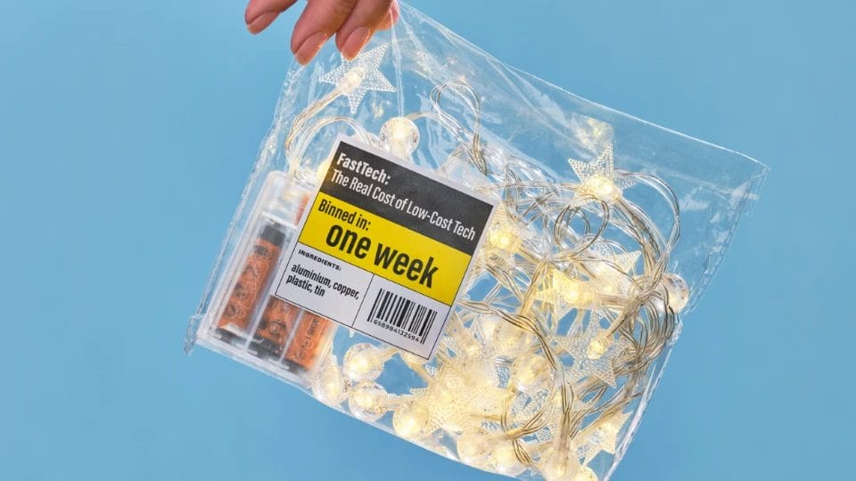 a pale skinned hand holding a clear plastic bag with some battery powered lights with writing saying "one week" on it